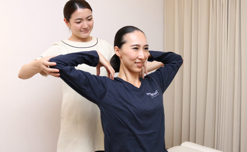 写真:スタッフとお客様が肘を持って肩のストレッチをしている
