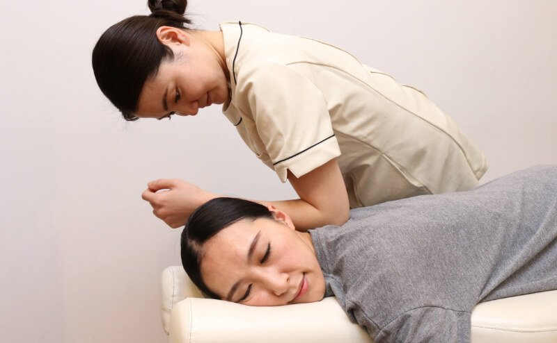 写真:セラピストがお客様の肩をほぐしている