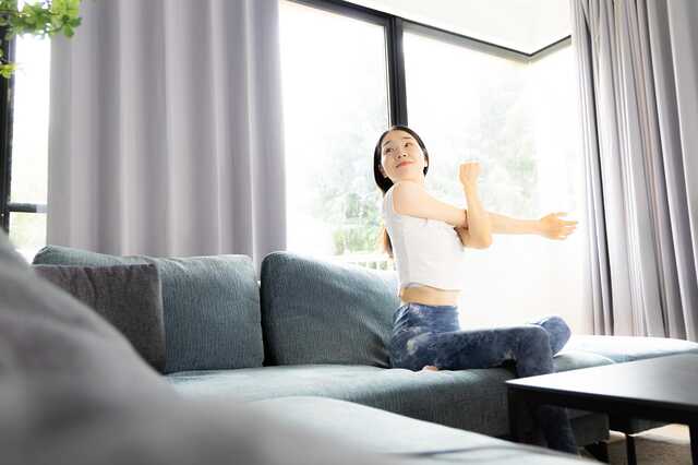 自宅で軽いストレッチをしている女性